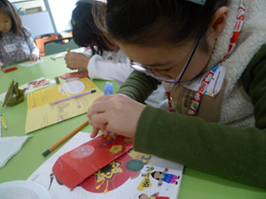 세벳돈봉투를 만들고 있는 어린이