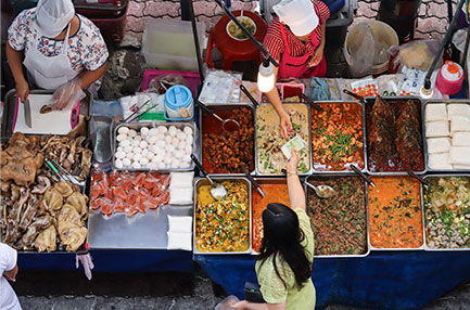 인도네시아 전통시장에서 반찬을 사는 여성